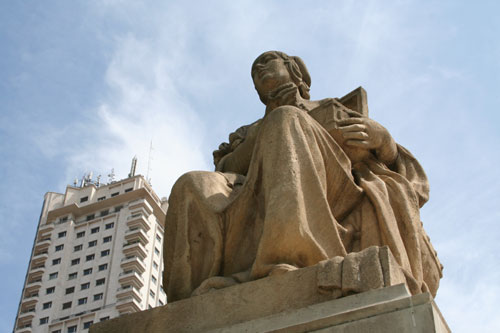 A statue on Plaza de Espana and Torre de Madrid